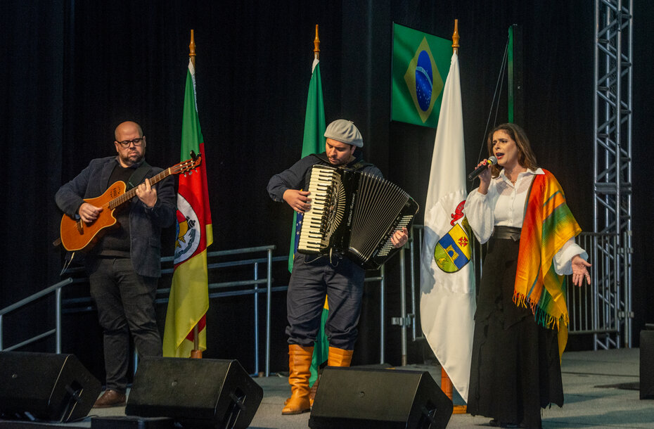 Shana Müller, acompanhada pelos músicos Felipe Barreto, violão, e Guilherme Goulart, 