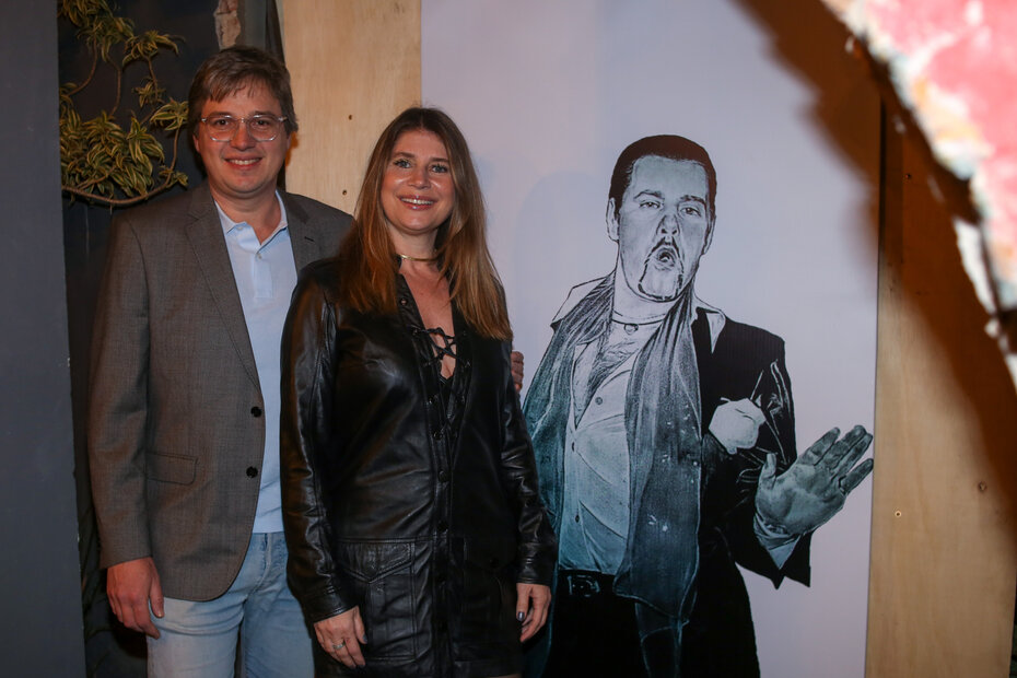 Eduardo Álvares Filho e Camile Marczyk, junto ao retrato de Tatata Pimentel, num dos recantos do Butikin (Foto: Lenara Petenuzzo/Divulgação)