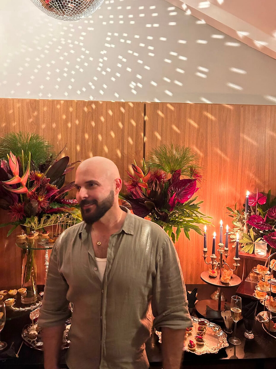 Mateus Concei&ccedil;&atilde;o junto &agrave; mesa decorada com belos arranjos florais de Pedro Martins (Foto: Maur&iacute;cio Rodrigues/Divulga&ccedil;&atilde;o)